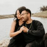 Couple enjoying a tender moment outdoors by a serene lake, showcasing love and togetherness.